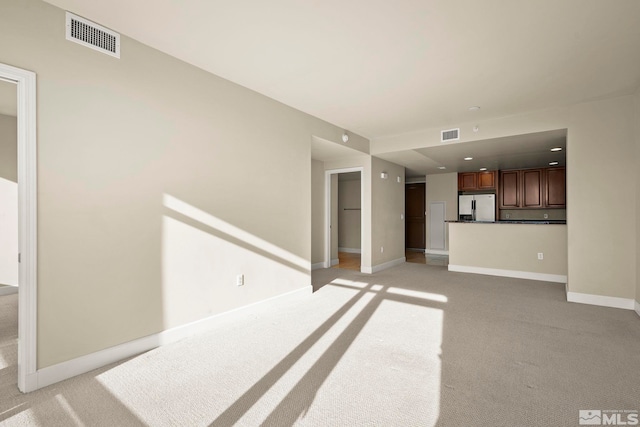 unfurnished living room with light colored carpet