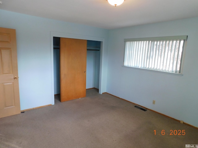 unfurnished bedroom with light carpet and a closet