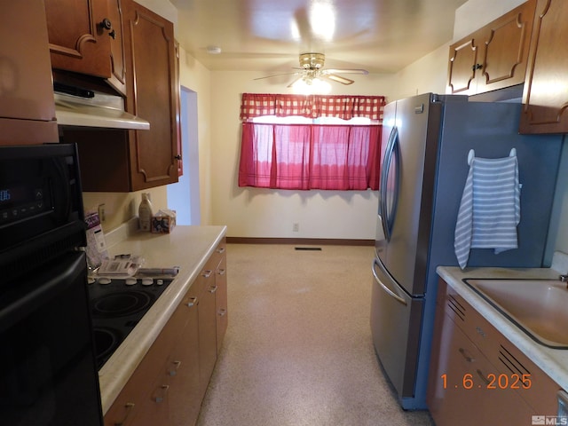 kitchen featuring ceiling fan, exhaust hood, sink, stovetop, and black oven