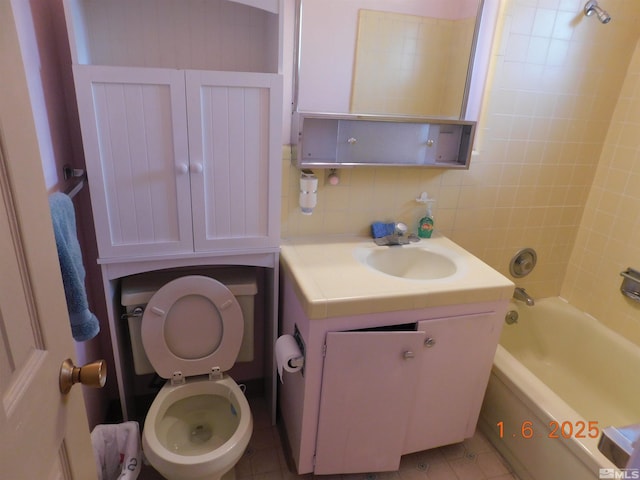 full bathroom featuring tile patterned flooring, vanity, toilet, and tiled shower / bath