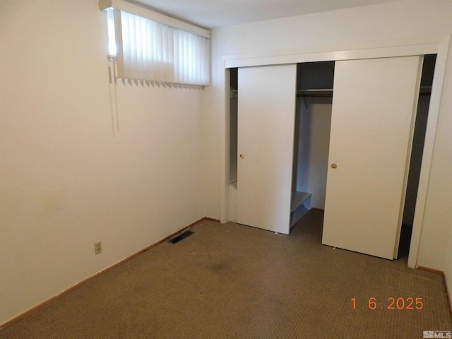 unfurnished bedroom featuring carpet and a closet