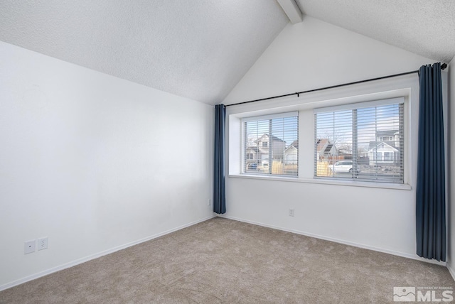 carpeted empty room featuring lofted ceiling with beams and a textured ceiling