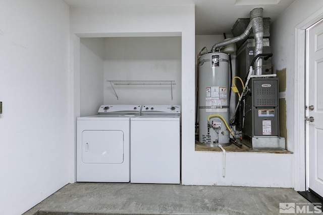 clothes washing area with washing machine and dryer and water heater