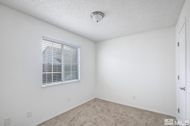 spare room with light carpet and a textured ceiling