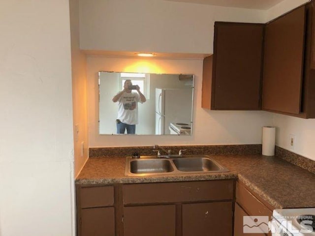 kitchen with stove, white fridge, and sink