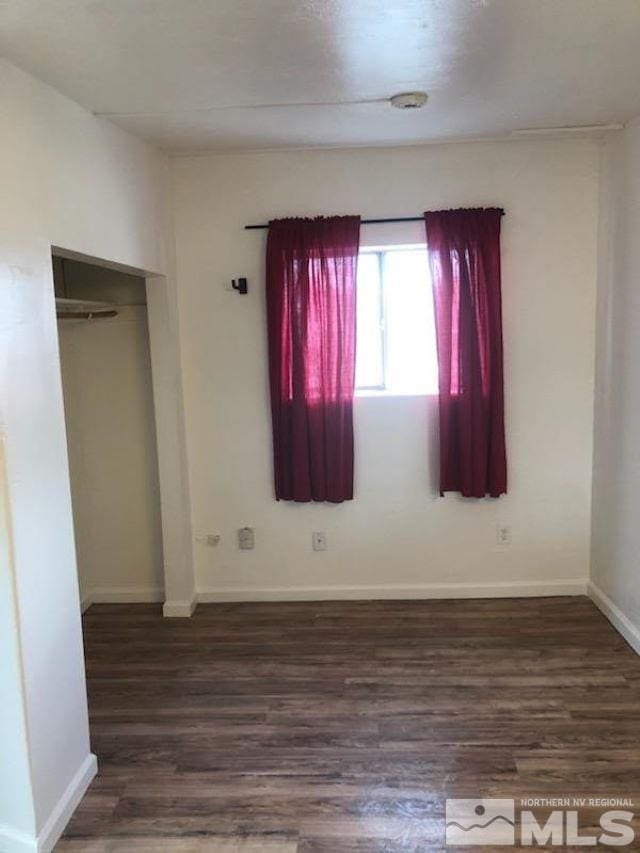 unfurnished bedroom with dark hardwood / wood-style floors