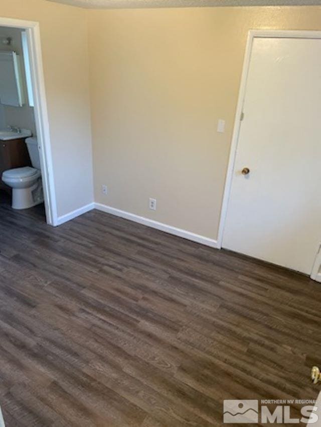 interior space featuring ensuite bath and dark wood-type flooring