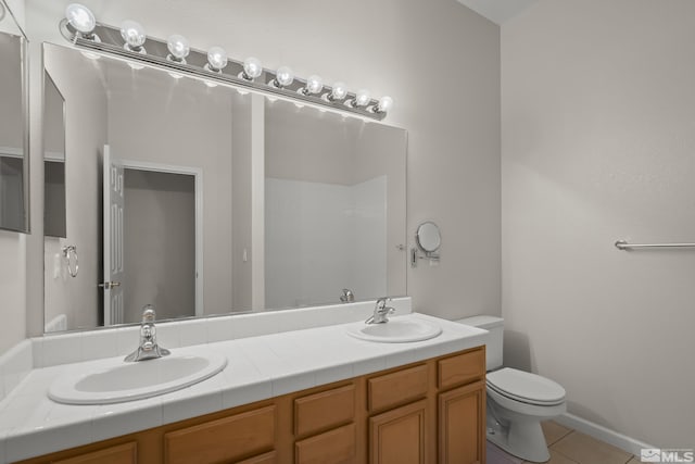 bathroom featuring tile patterned flooring, vanity, and toilet