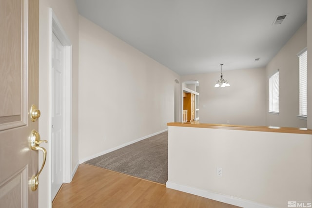 interior space featuring hardwood / wood-style floors, light brown cabinets, and a chandelier