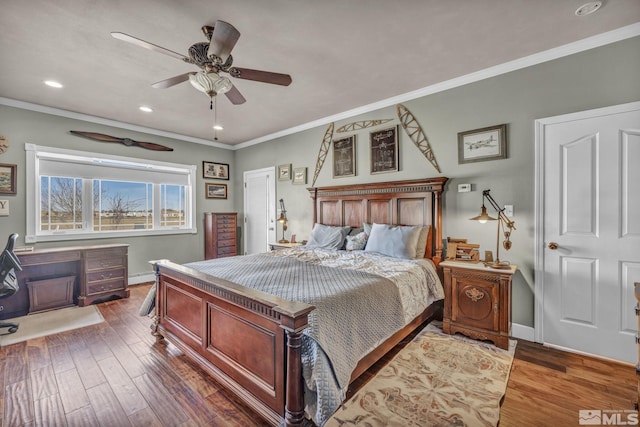 bedroom featuring baseboard heating, ceiling fan, dark hardwood / wood-style flooring, and ornamental molding