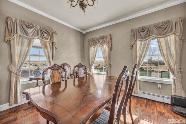 dining area featuring an inviting chandelier, a water view, ornamental molding, baseboard heating, and wood-type flooring