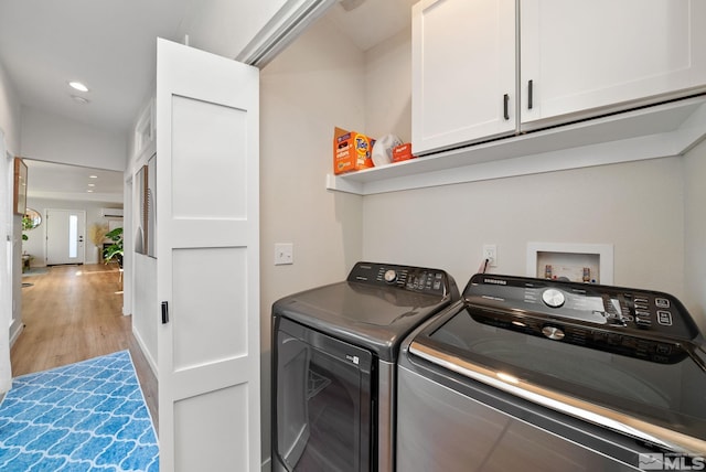 laundry room featuring washer and dryer and light wood-type flooring