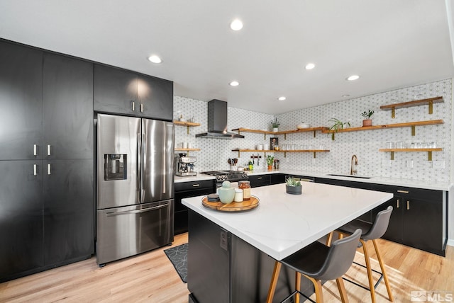 kitchen featuring stainless steel fridge, sink, wall chimney exhaust hood, and a kitchen island