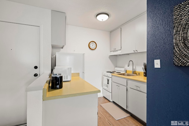 kitchen featuring white cabinets, light hardwood / wood-style floors, white range, and sink