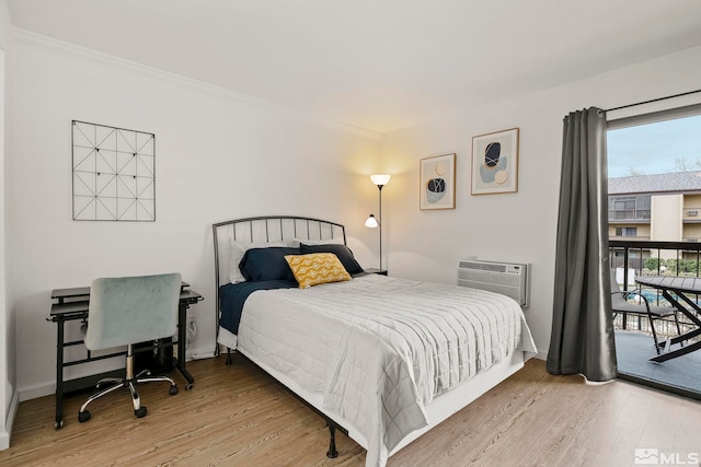 bedroom with access to outside, a wall mounted AC, ornamental molding, and hardwood / wood-style flooring