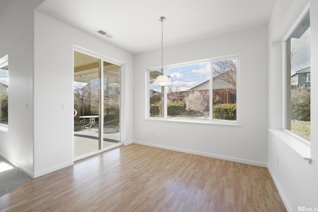 unfurnished dining area featuring wood-type flooring and an inviting chandelier