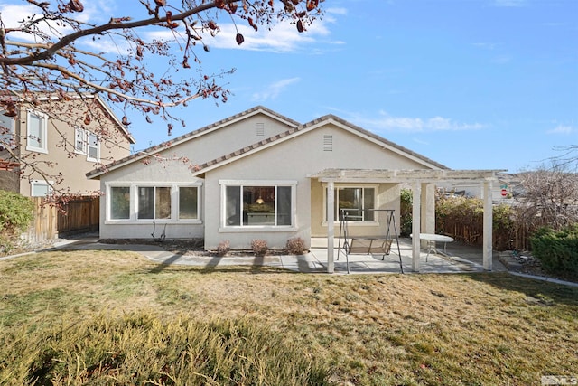 back of house with a pergola, a patio area, and a lawn