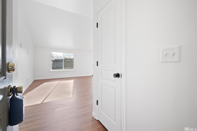 hallway with hardwood / wood-style flooring