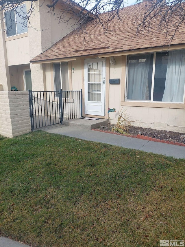 property entrance with a lawn