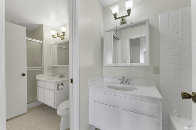 bathroom with vanity, toilet, and a shower