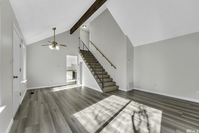 unfurnished living room featuring high vaulted ceiling, dark hardwood / wood-style floors, beam ceiling, and ceiling fan