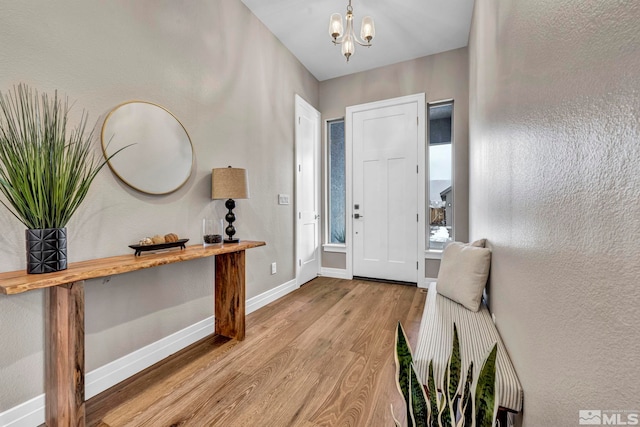 entrance foyer with light hardwood / wood-style floors and a chandelier