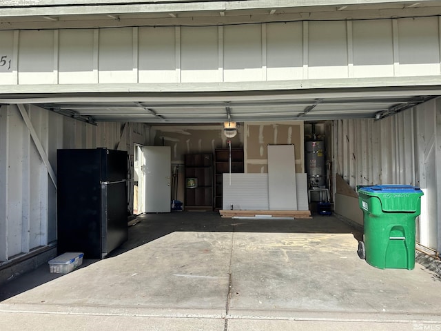 garage featuring black fridge, water heater, and a garage door opener