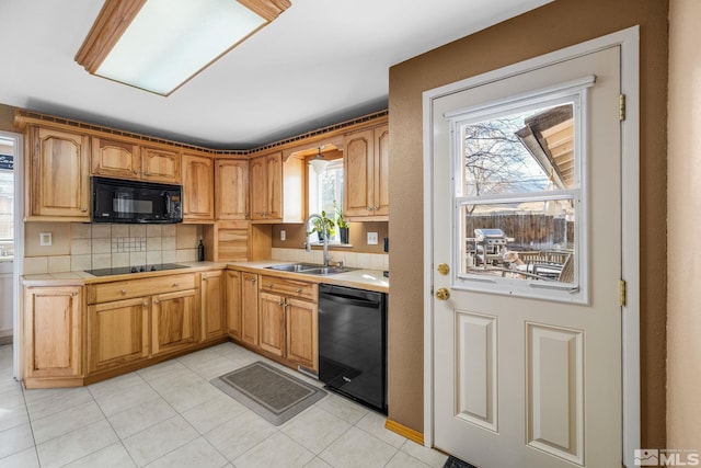 kitchen featuring decorative backsplash, sink, a healthy amount of sunlight, and black appliances