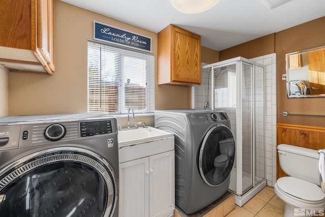 washroom with independent washer and dryer, light tile patterned floors, and sink