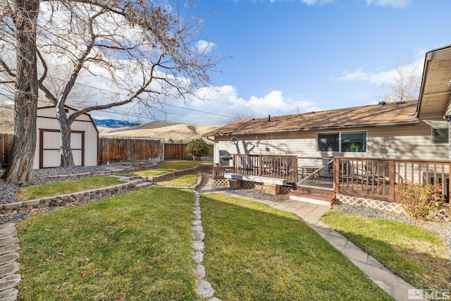 view of yard with a shed and a deck with mountain view