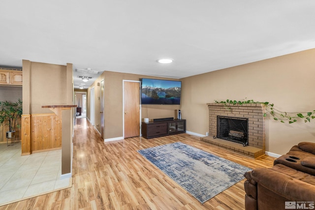 living room featuring light hardwood / wood-style flooring and a brick fireplace