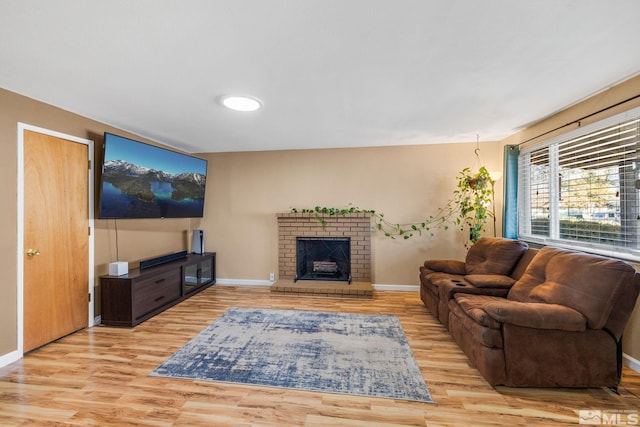 living room with light wood-type flooring and a brick fireplace