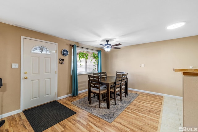 dining space with ceiling fan and light wood-type flooring