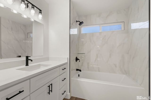 bathroom featuring vanity, hardwood / wood-style flooring, and tiled shower / bath