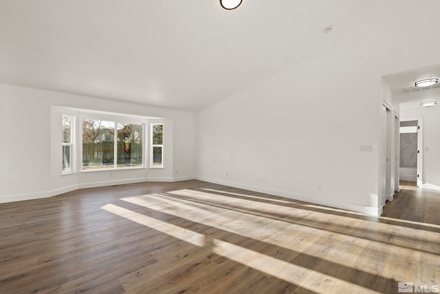 unfurnished room featuring dark hardwood / wood-style floors and lofted ceiling