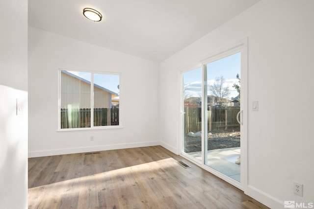 empty room featuring light hardwood / wood-style floors and vaulted ceiling