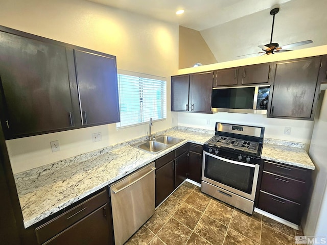 kitchen with sink, ceiling fan, appliances with stainless steel finishes, dark brown cabinets, and light stone counters