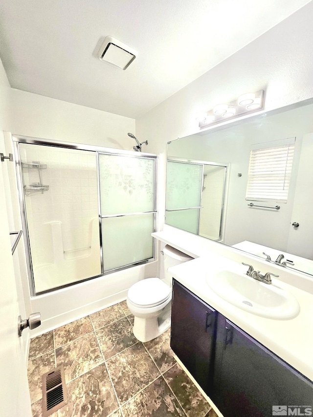 full bathroom featuring shower / bath combination with glass door, vanity, and toilet