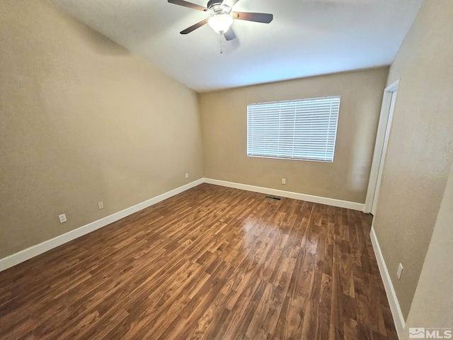 empty room featuring dark hardwood / wood-style flooring and ceiling fan