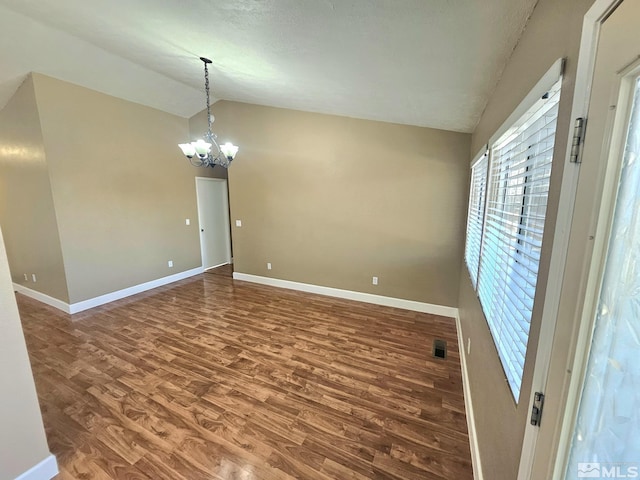 unfurnished room with a chandelier, hardwood / wood-style floors, and lofted ceiling