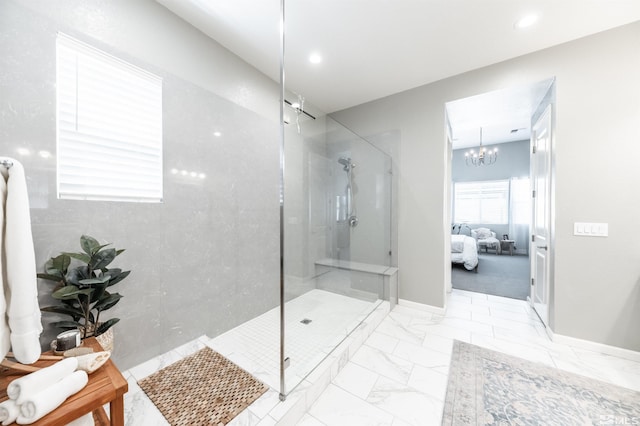 bathroom with a notable chandelier and a tile shower