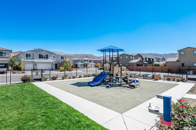 view of play area with a mountain view and a yard