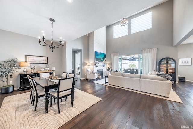 dining area with a chandelier, a towering ceiling, and dark wood-type flooring