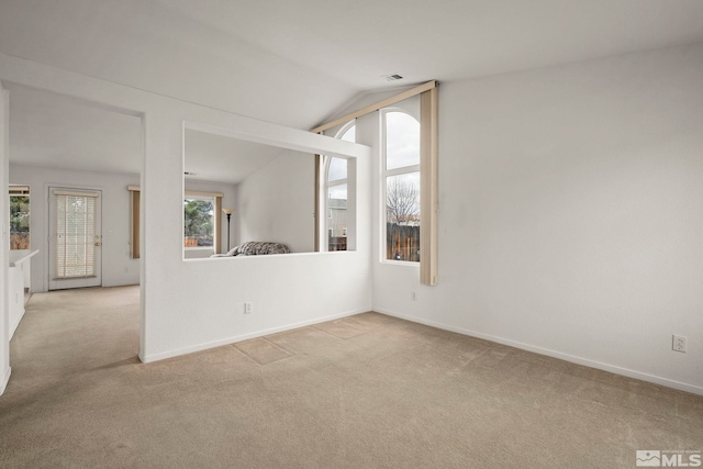 carpeted empty room with lofted ceiling