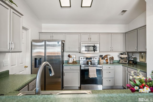 kitchen featuring gray cabinetry and stainless steel appliances