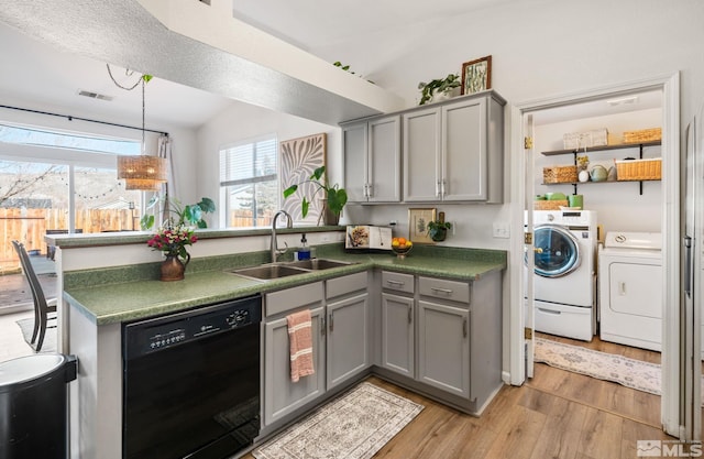 kitchen with gray cabinetry, dishwasher, washing machine and dryer, and sink