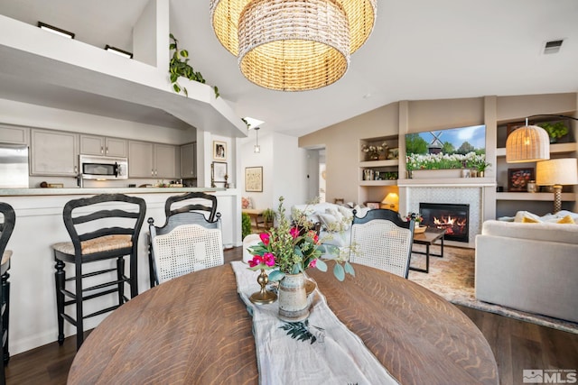 dining area featuring vaulted ceiling and dark wood-type flooring