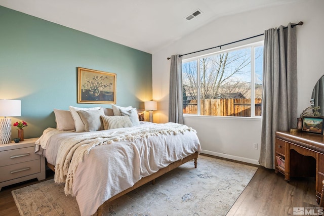 bedroom with dark wood-type flooring and vaulted ceiling