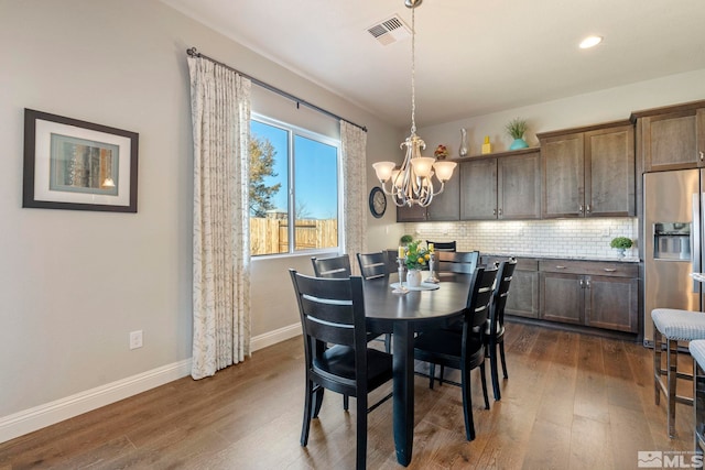 dining room with dark hardwood / wood-style floors and a notable chandelier