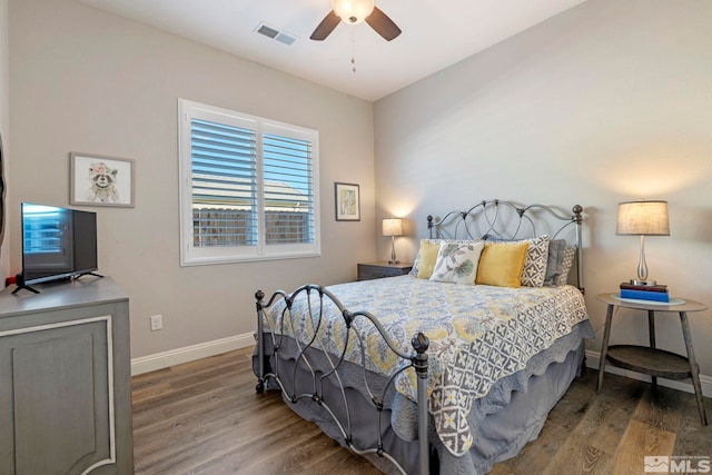 bedroom with dark hardwood / wood-style flooring and ceiling fan